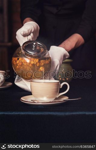 Pouring tea with sea buckthorn. Pouring tea with sea buckthorn honey and herbs in glass teapot