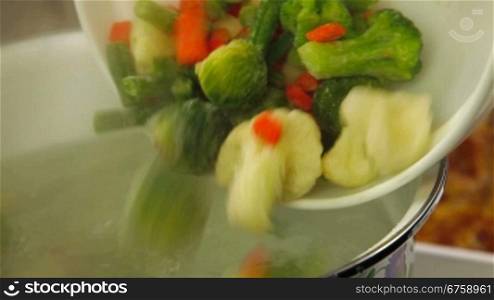 Pouring the vegetables in a pot with boiling water