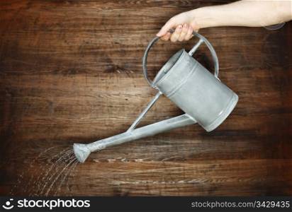 Pouring water with a metallic watering can.