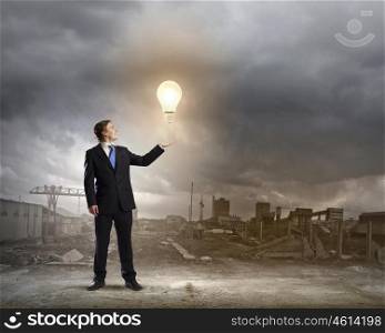 Power and energy. Young businessman holding light bulb in palm