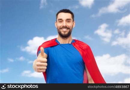 power and people concept - happy man in red superhero cape showing thumbs up over blue sky and clouds background. happy man in red superhero cape showing thumbs up