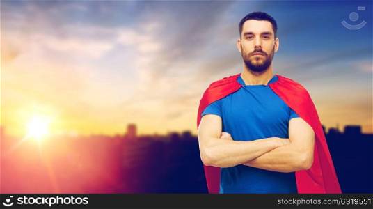 power and people concept - man in red superhero cape over city and sun light background. man in red superhero cape over city background