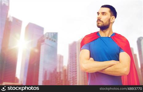 power and people concept - man in red superhero cape over singapore city skyscrapers background. man in red superhero cape over city skyscrapers