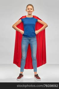 power and people concept - smiling teenage girl in red superhero cape over grey background. smiling teenage girl in red superhero cape