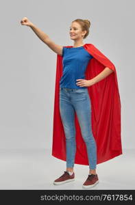 power and people concept - smiling teenage girl in red superhero cape over grey background. smiling teenage girl in red superhero cape