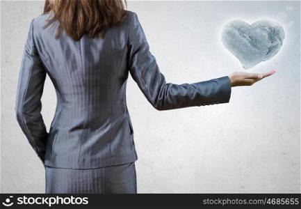 Power concept. Businesswoman pointing with finger at huge stone