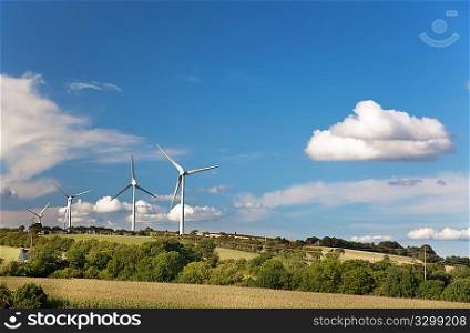 Power Generating Windmills in a countryside landscape, summer and clear sky.