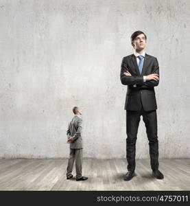 power in business. Big bossy businessman looking down at small businessman