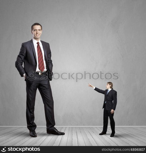 power in business. Big bossy businessman looking down at small businessman