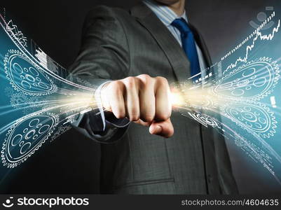 Power in business. Close up of businessman holding hologram of cogwheels in fist