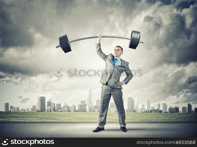 Power in business. Image of strong businessman lifting barbell above head with one hand