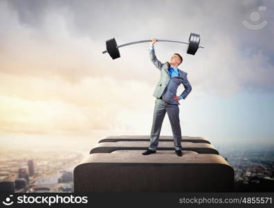 Power in business. Image of strong businessman lifting barbell above head with one hand