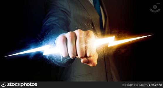 Power in hands. Businessman holding lightning in fist. Power and control