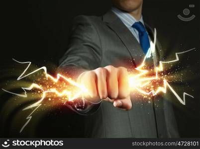 Power in hands. Close up of businessman hand holding lightning in fist