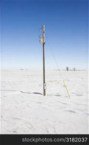 Power line in desolate snow covered rural landscape.