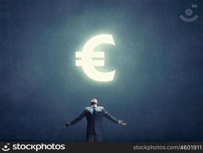 Power of money. Businessman with hands spread apart and euro sign above