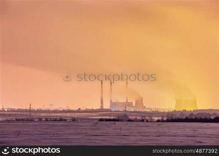 Power plant and cooling towers at dusk near the city