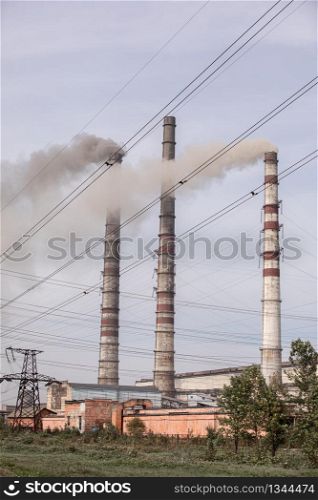 Power plant is creating energy for the people. High voltage post. Smoke from the chimneys against the sky. selective focus