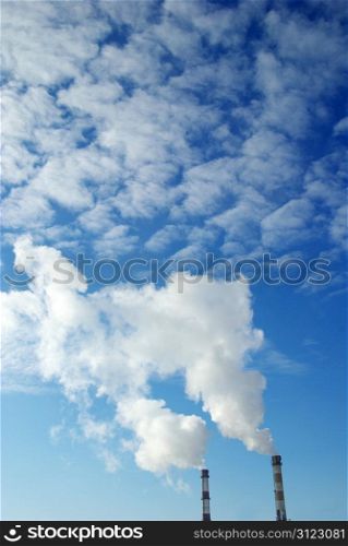 Power plant with smoke under sky