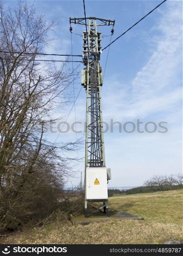 Power pole in detail against a blue sky. Electricity pylon