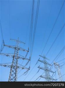 power pylons and electricity wires contrasting against blue sky