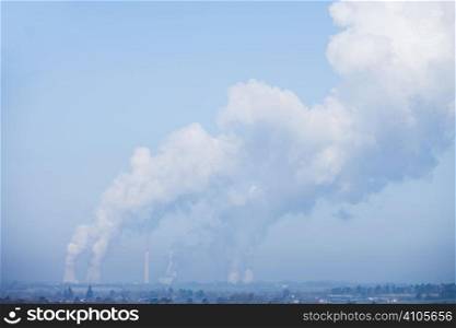 power station bellowing emitting smoke from chimneys