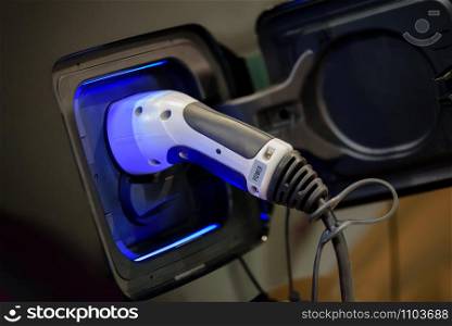 Power supply plugged into an electric car during charging.