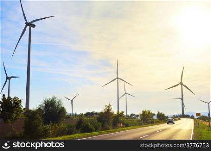 Power wing turbines and road in Germany at sunset