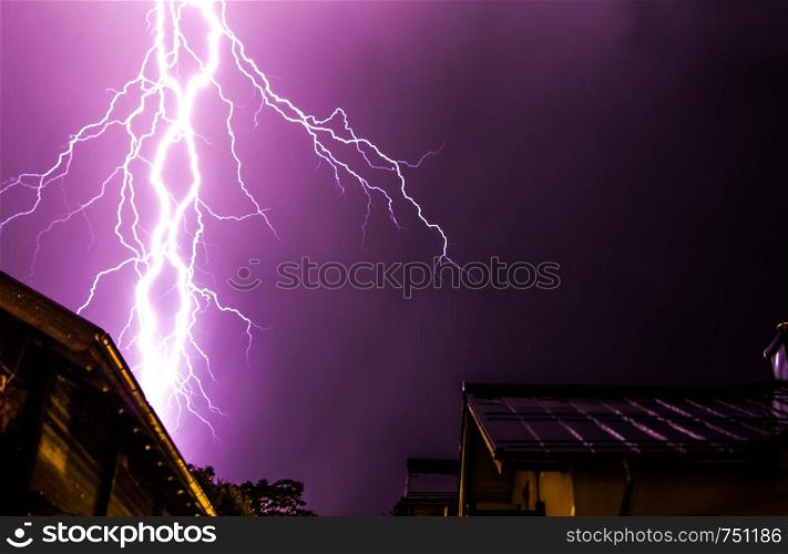 Powerful Lightning on the cloudy sky, building in foreground, Austria
