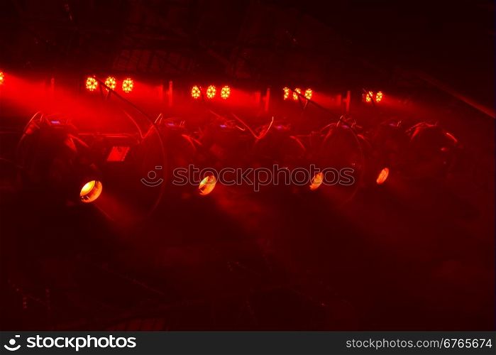 Powerful spotlights illuminate the scene with red light
