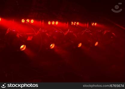 Powerful spotlights illuminate the scene with red light