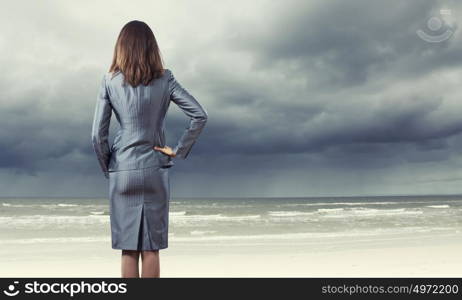 Powerful woman. Back view of confident businesswoman with arm on waist