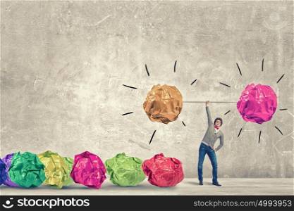 Powerlifter of great ideas. Man lifting in hand big crumpled ball of colorful paper as creativity sign
