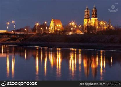 Poznan Cathedral, Archcathedral Basilica of St Peter and St Paul at night with reflection in Warta River, Poznan, Poland. Poznan Cathedral at sunset, Poland