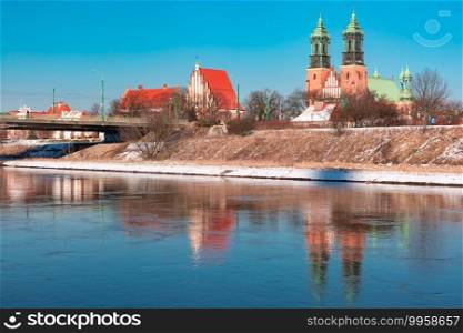 Poznan Cathedral with reflection in Warta River in the winter sunny day, Poznan, Poland. Poznan Cathedral in winter, Poland
