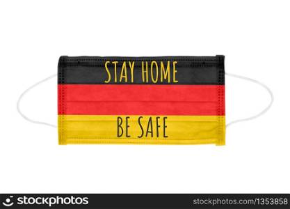 PP non-woven disposable medical face mask isolated on white background. Stay home and be safe lettering on medical mask toned in Germany flag colors. PP non-woven disposable medical face mask isolated on white background