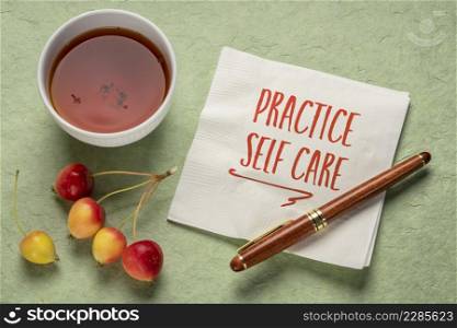 practice self care - inspirational reminder, handwriting on a napkin with a cup of tea, lifestyle and health concept
