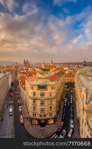 Prague red roofs and spires of historical Old Town of Prague. Cityscape of Prague on a sunset frosty. Red rooftops, spires and Prague castle in the background. Prague, Czechia. Space for text