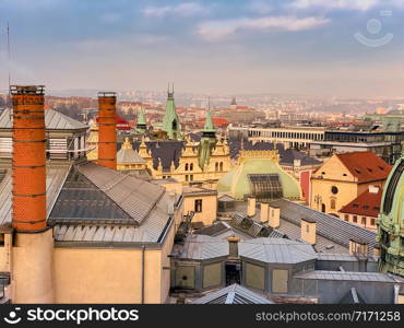 Prague red roofs and spires of historical Old Town of Prague. Cityscape of Prague on a sunset frosty. Red rooftops, spires and Prague castle in the background. Prague, Czechia. Space for text