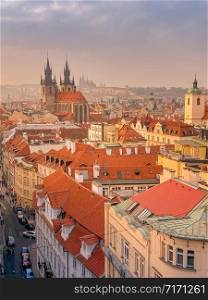 Prague red roofs and spires of historical Old Town of Prague. Cityscape of Prague on a sunset frosty. Red rooftops, spires and Prague castle in the background. Prague, Czechia. Space for text
