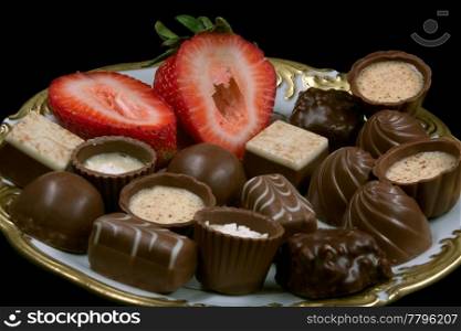 pralines decorated with a strawberry on a plate