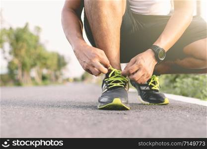 Pranakornsri-ayutthaya, Thailand - October 15, 2018 : Young runner Tied the shoe laces on the runway.Intermediate