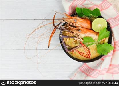 Prawn spicy soup bowl / Cooked seafood with shrimp soup dinner table and spices ingredients thai food asian traditional , Tom Yum Kung top view copy space