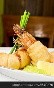 Prawn wrapped in pastry with garnishes on plate