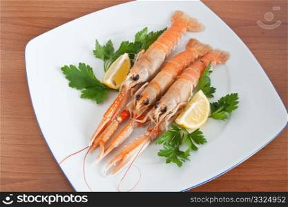 prawns with lemon and parsley on a white plate