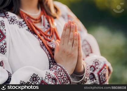 Pray for Ukraine, stand with. Ukrainian woman in traditional embroidery vyshyvanka dress holding hands in prayer gesture - anjali mudra. High quality photo. Pray for Ukraine, stand with. Ukrainian woman in traditional embroidery vyshyvanka dress holding hands in prayer gesture - anjali mudra.