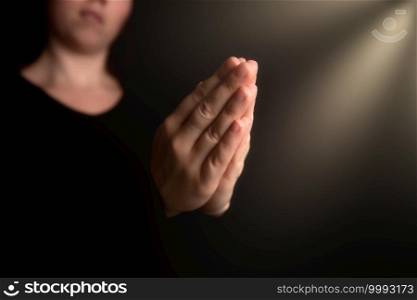 Praying hands with faith in religion and belief in God on blessing background. Power of hope or love and devotion in the dark with copy space , space for text. Praying hands with faith in religion and belief in God on blessing background. Power of hope or love and devotion in the dark with copy space