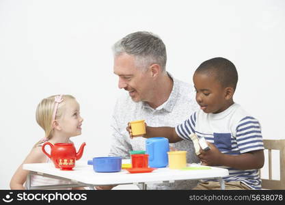 Pre School Children Enjoying Tea Party With Teacher