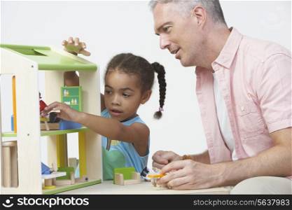 Pre-School Teacher And Pupil Playing With Wooden House