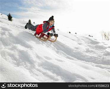 Pre-teen Boy On A Sled In The Snow
